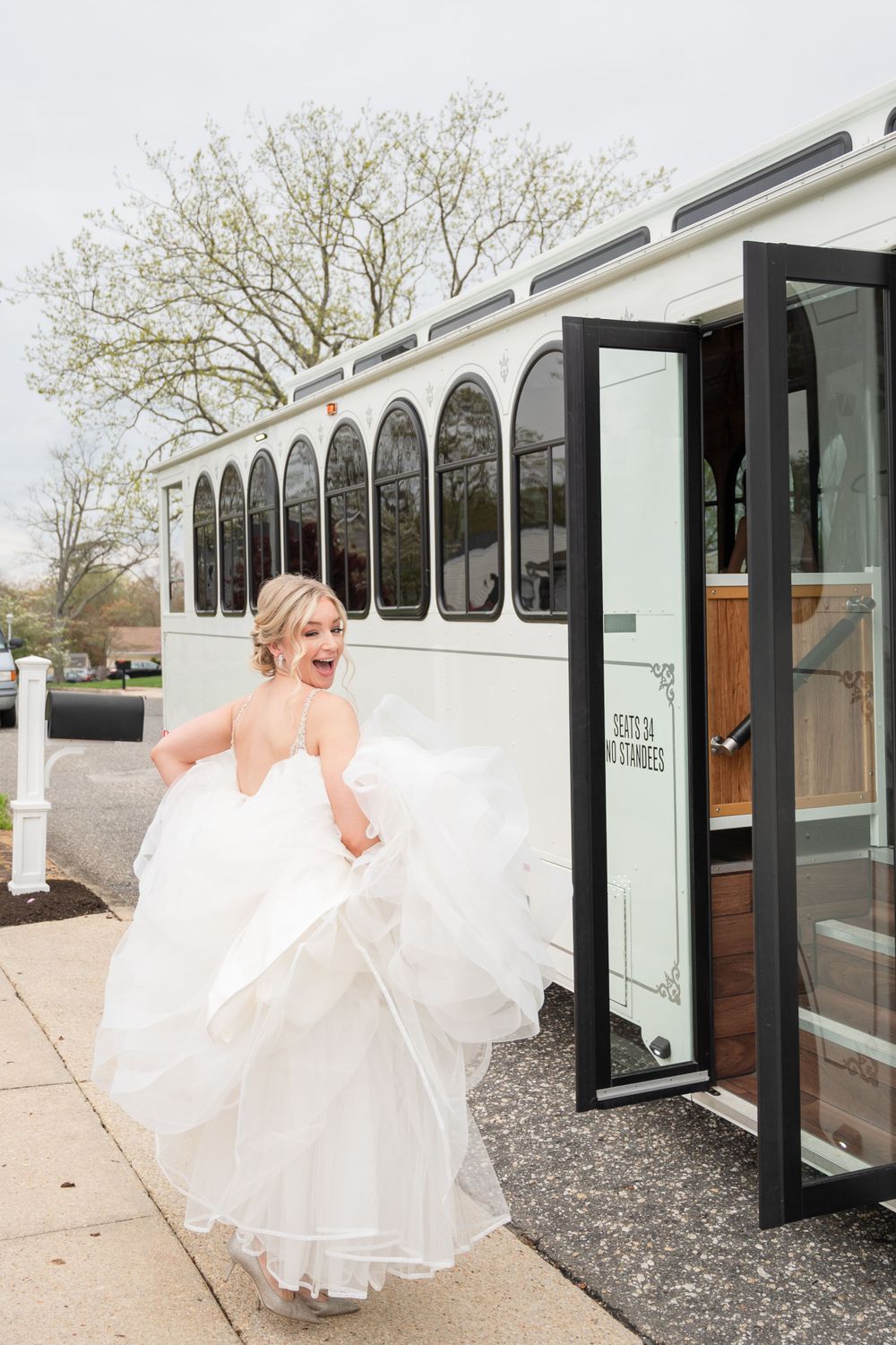 Sequence of bride entering white shuttle bus in flowing wedding dress.