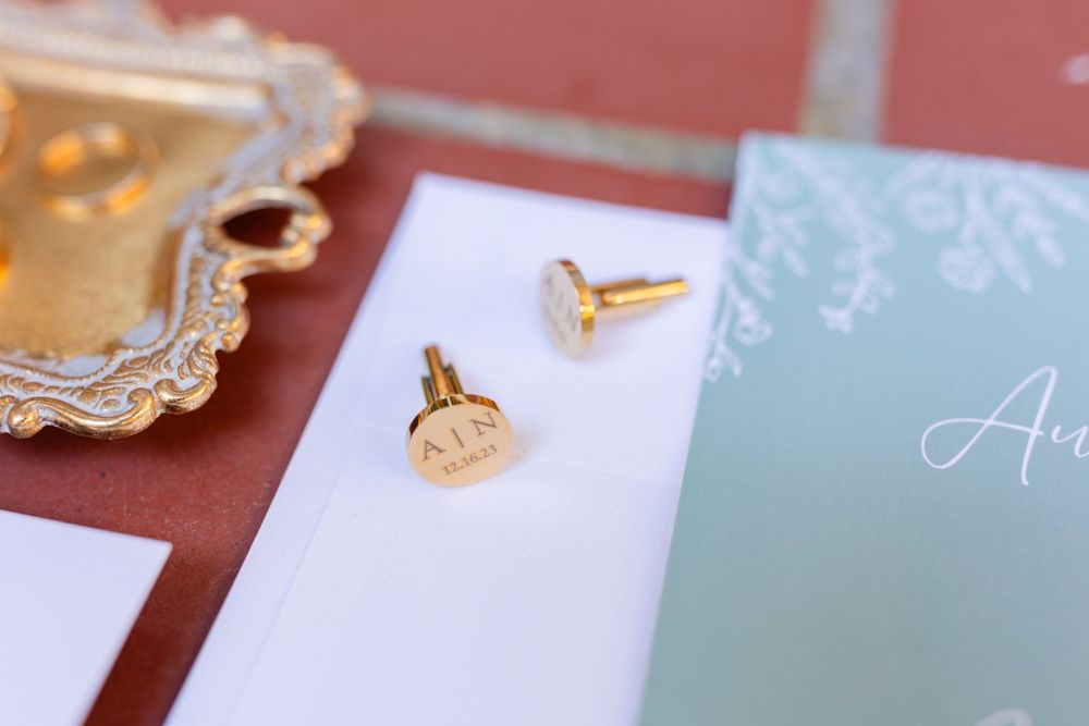 Close-up of wedding jewelry and invitation details in mint and gold colors.