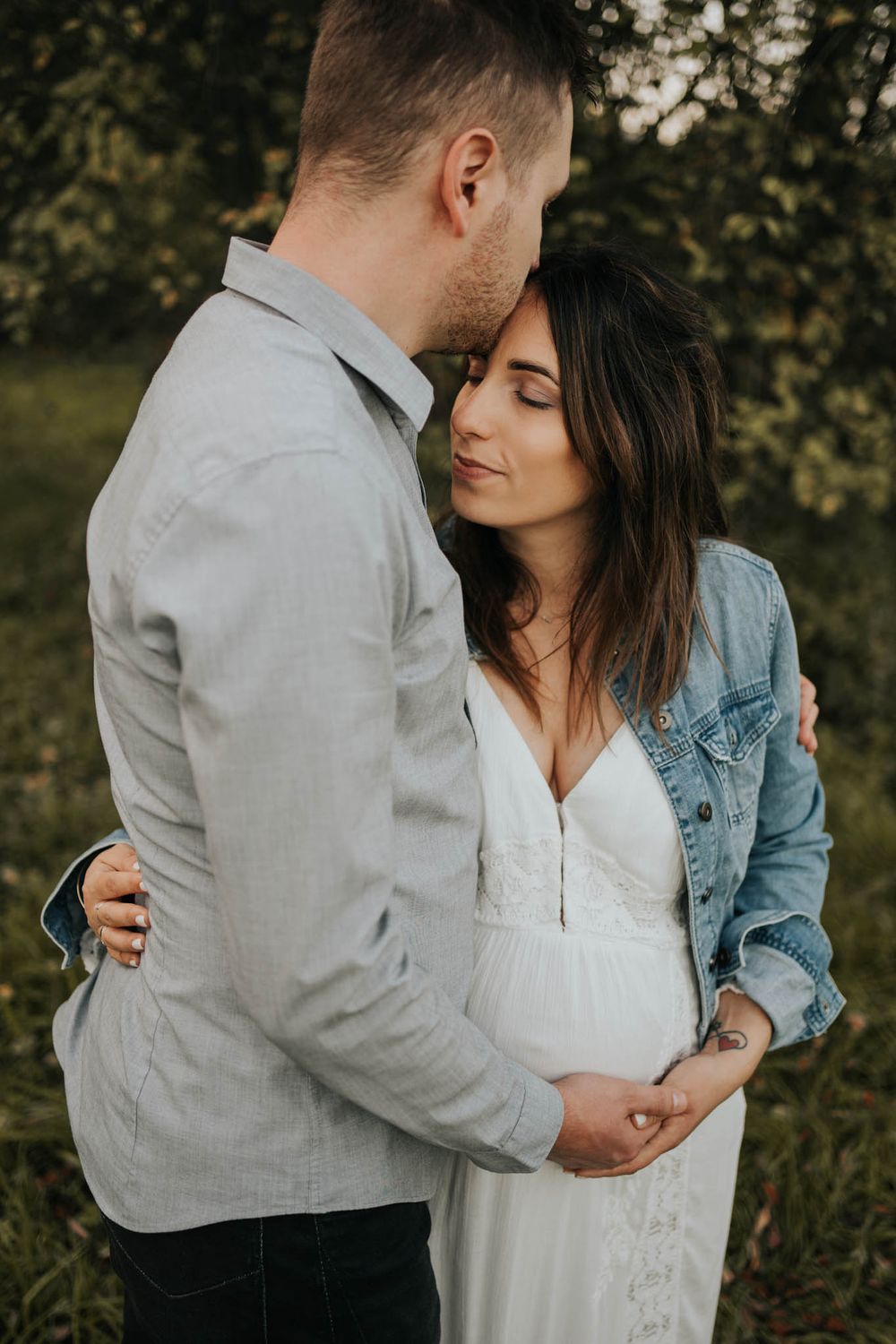 mama w sukience boho przytulana i całowana przez tatę -  fotograf ciążowy Kraków