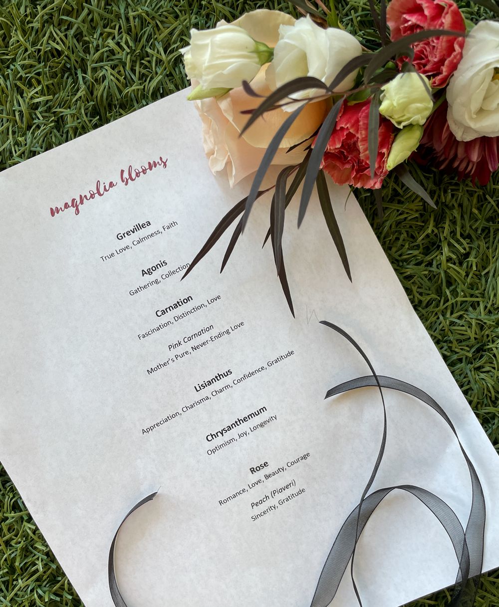 Event menu on grass with red and white floral decorations.