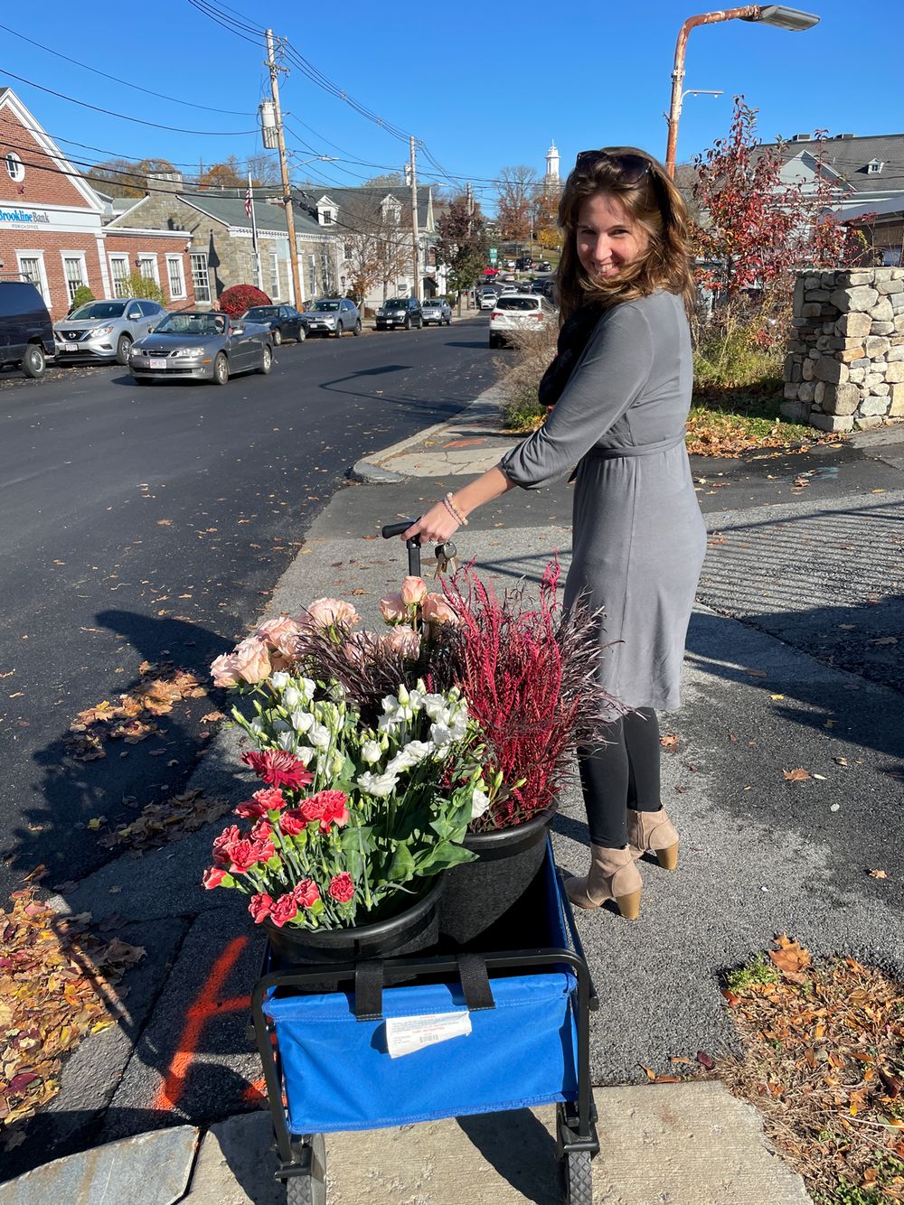 Fall street scene with cart full of seasonal flowers and decorations.