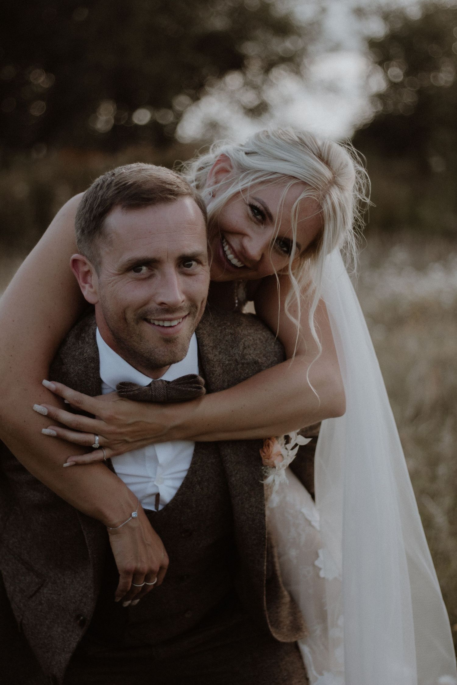 A joyful wedding portrait showing a couple sharing a candid moment outdoors.