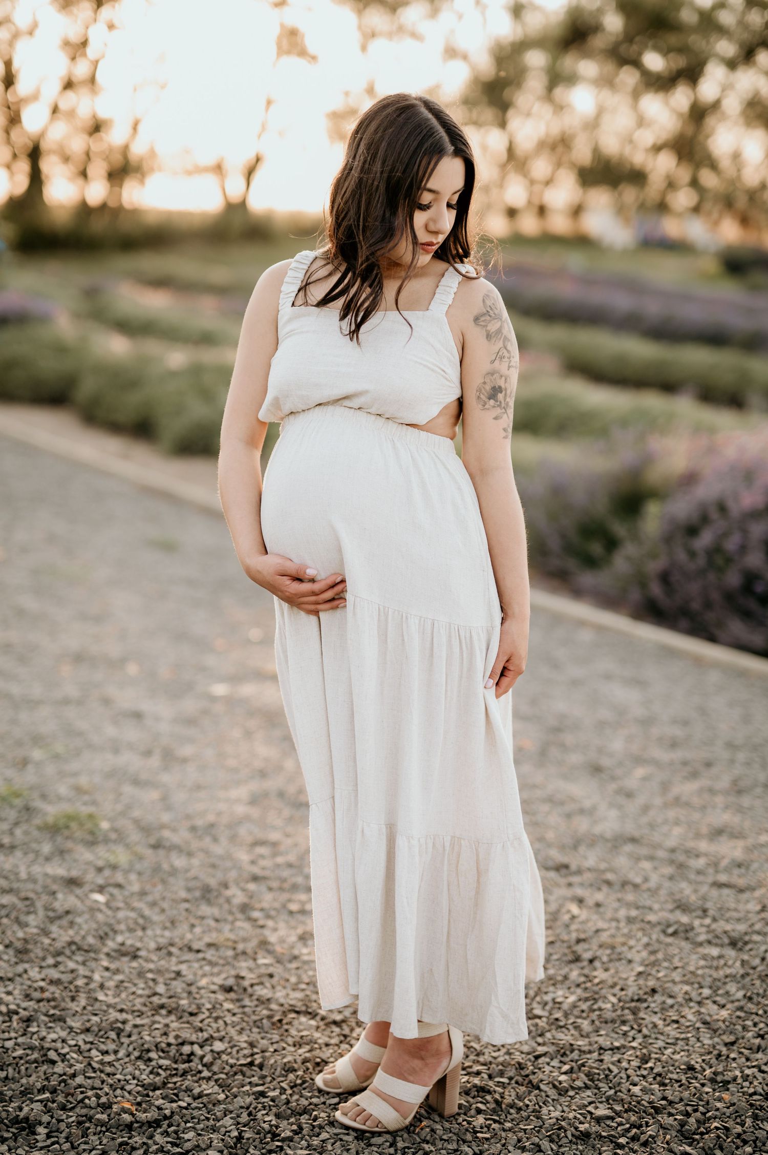 pregnant mother standing near lavender field during maternity session