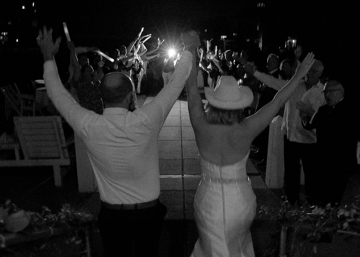 Wedding reception dance party with guests celebrating in black and white.
