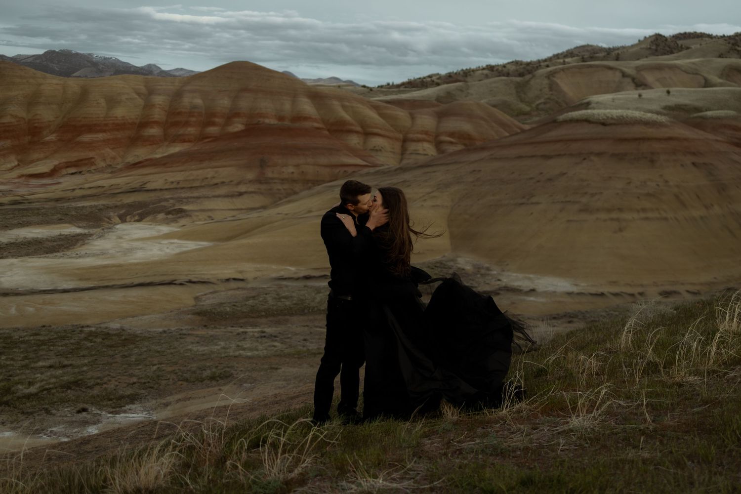 Silhouettes against a dramatic desert landscape during sunset.