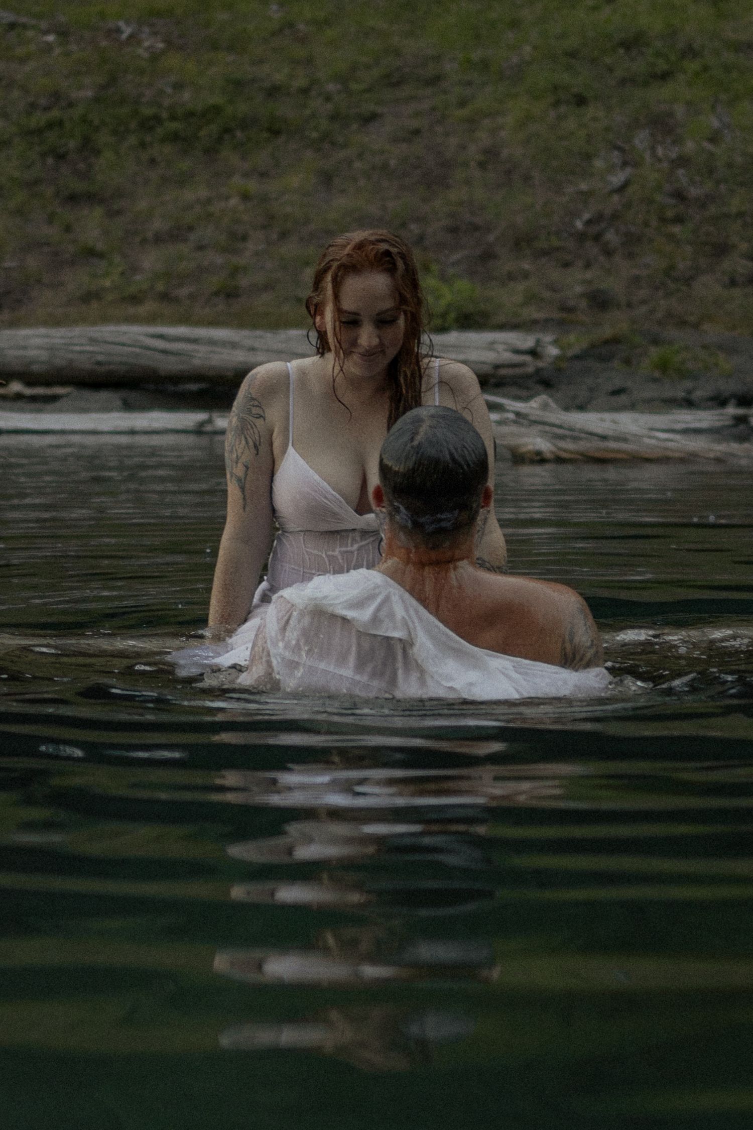 Ethereal water photography of a couple in formal wear submerged in a lake.