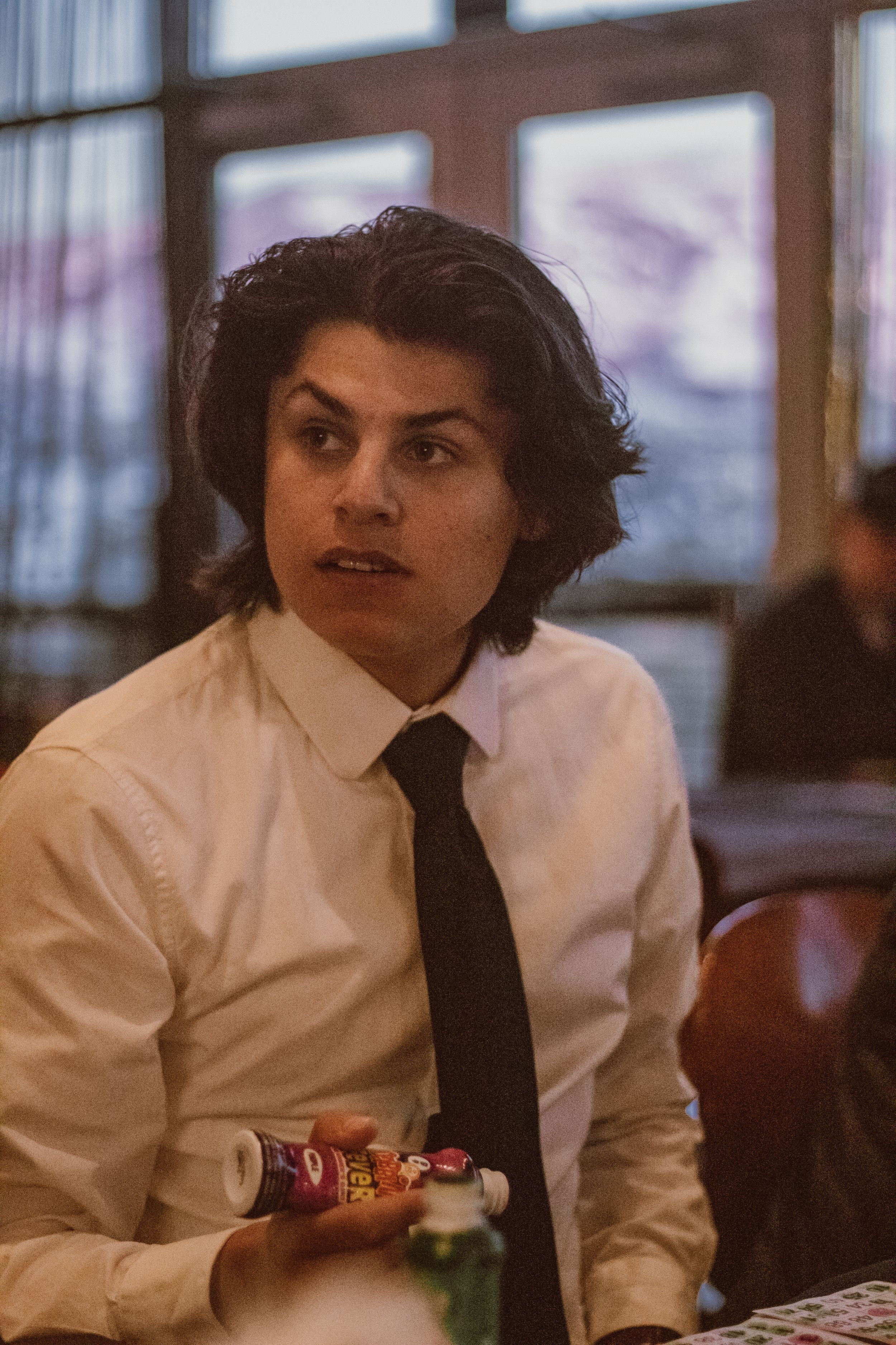 Person in formal attire seated at dining table during evening event.