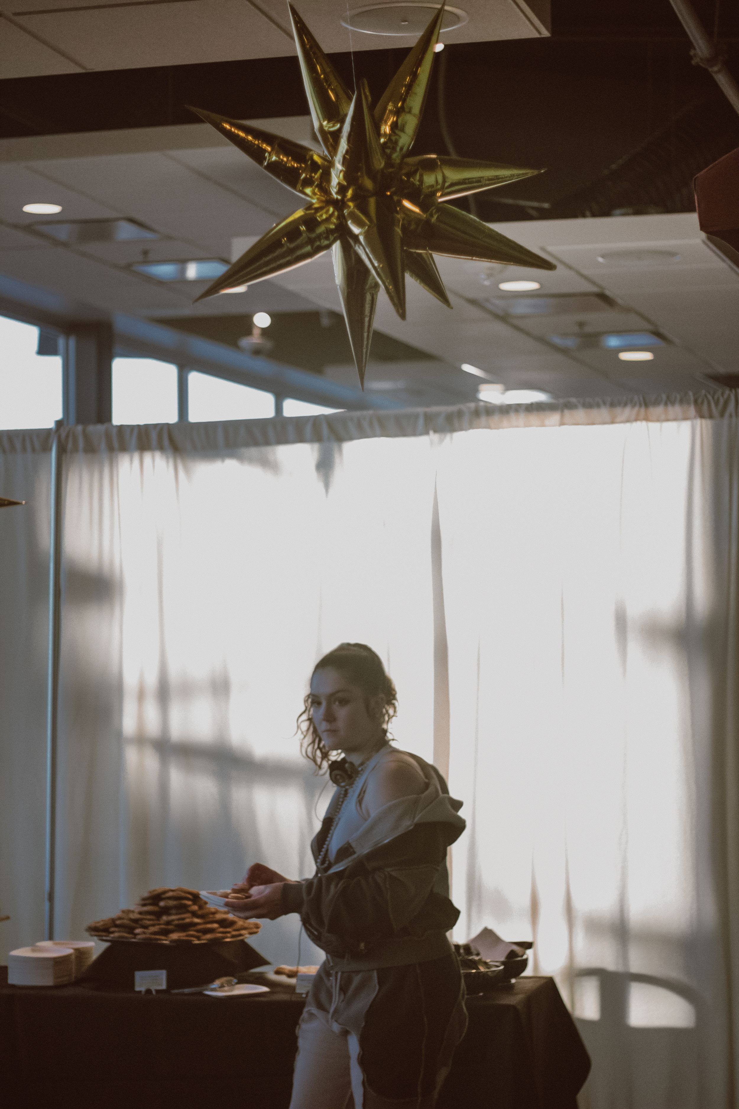 Large gold star decorations suspended from ceiling in modern office space.