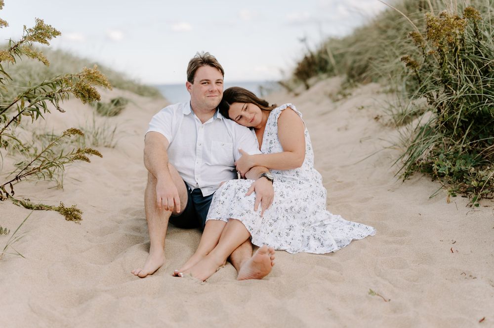 Couple relaxing together on sandy beach path during golden hour.