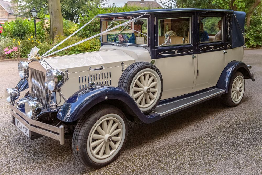 vintage wedding car arrives at west tower with the bride and her father