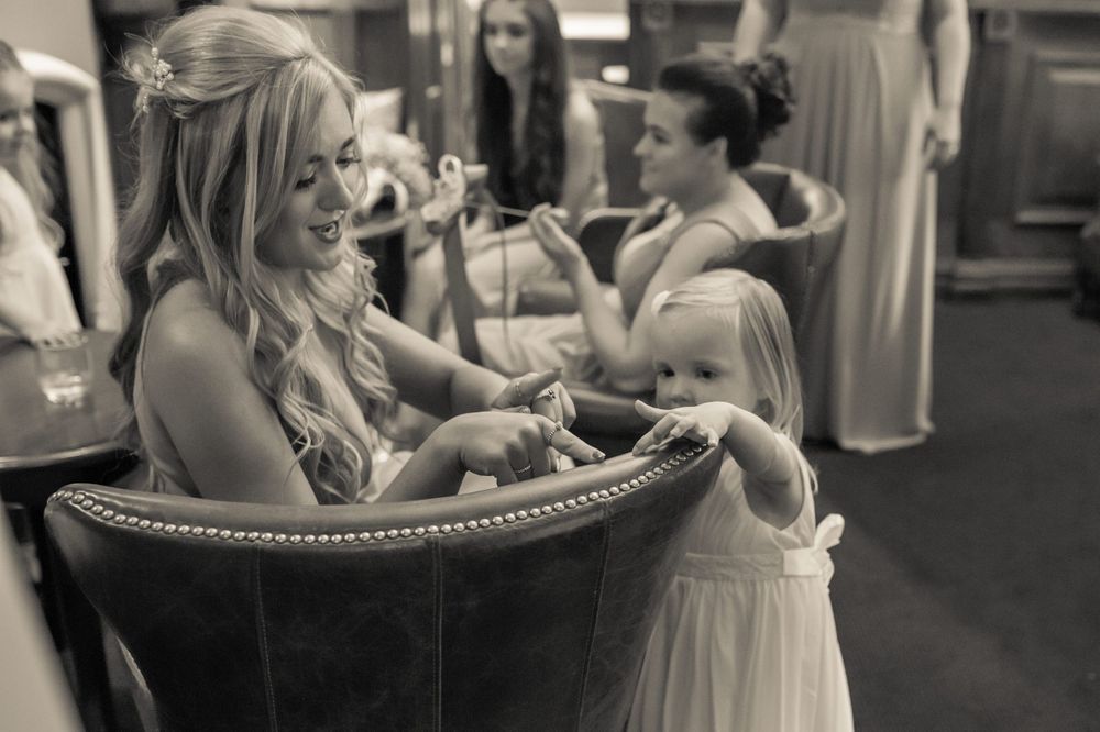 flower girl playing with one of the bridesmaids in the reception area at west tower exclusive wedding venue