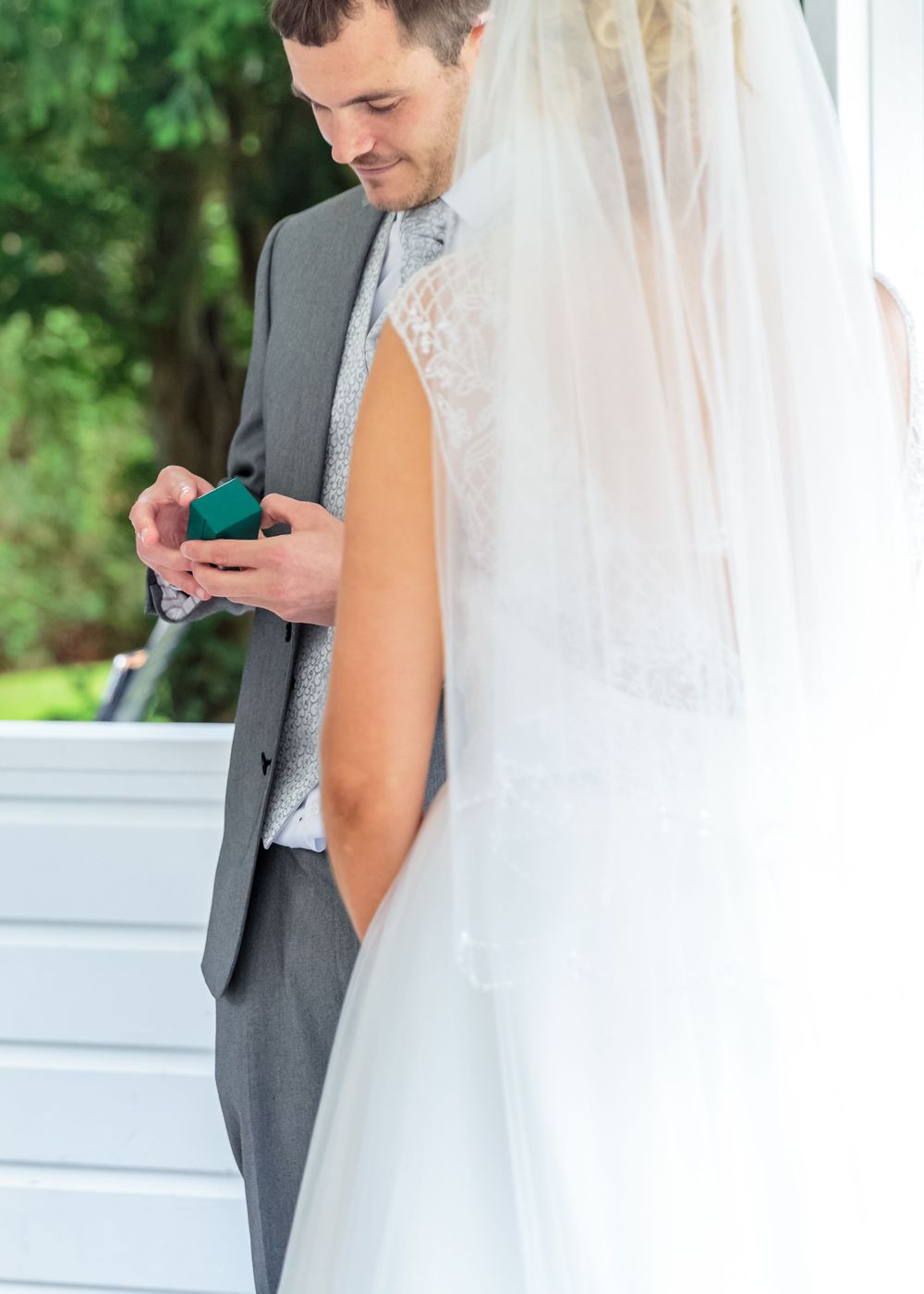 groom opens the wedding ring box in front of the bride at west tower