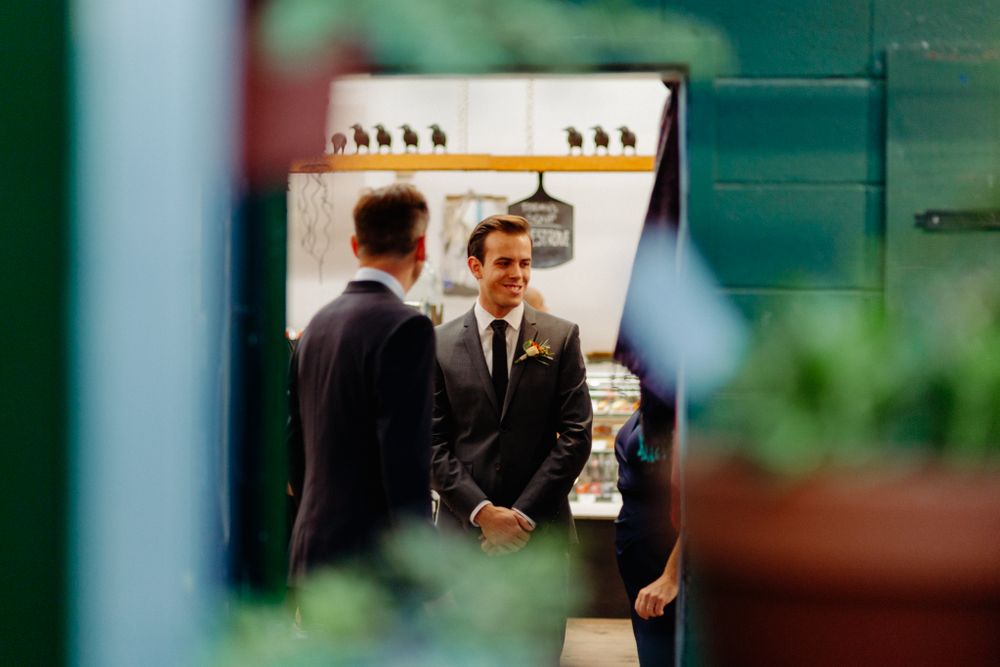 Two people in suits having a conversation reflected in a mirror.