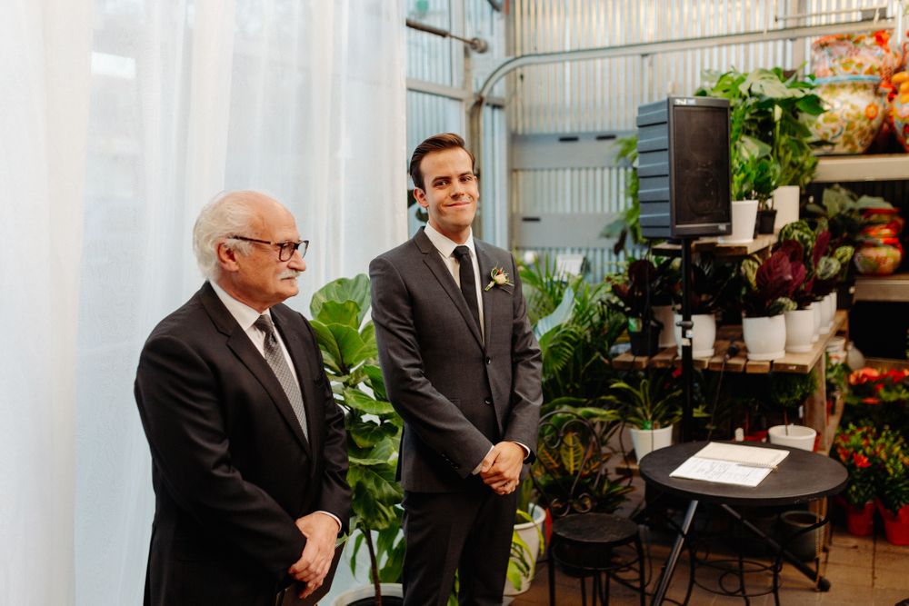 An indoor garden ceremony setting with potted plants and floral displays.