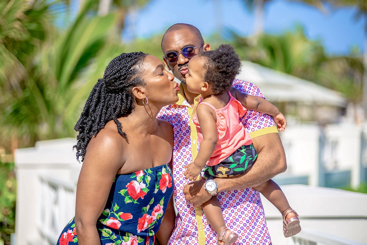 father, mother and young baby girl kissing