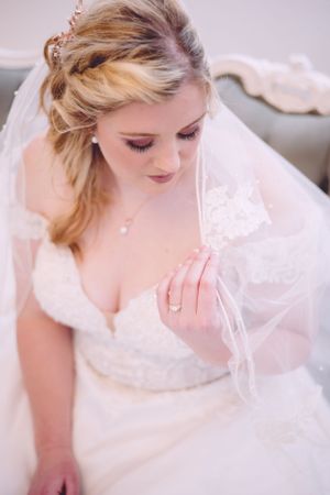 Close-up portrait of a bride wearing a delicate veil and wedding gown.