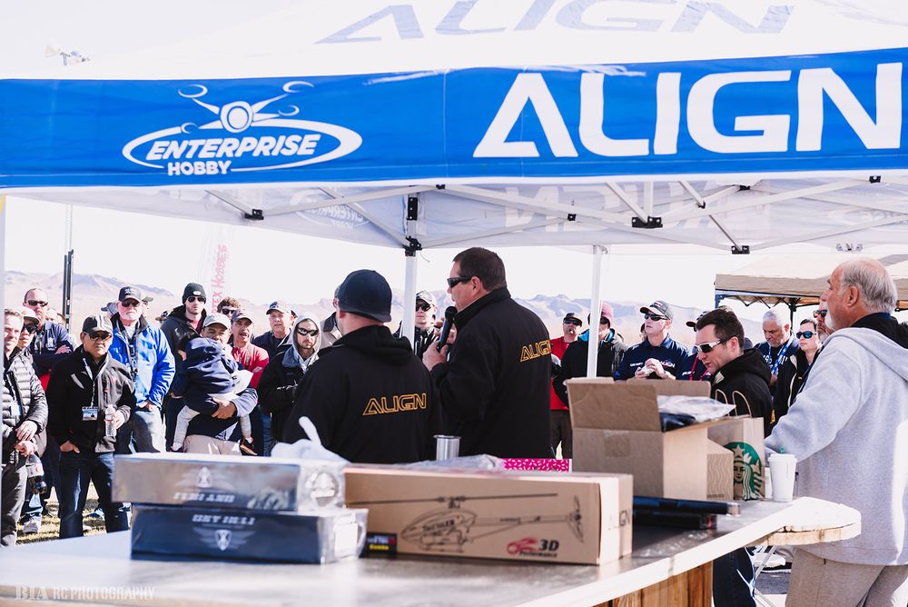 Busy vendor booth at RC event with Align banner and merchandise displayed on tables.