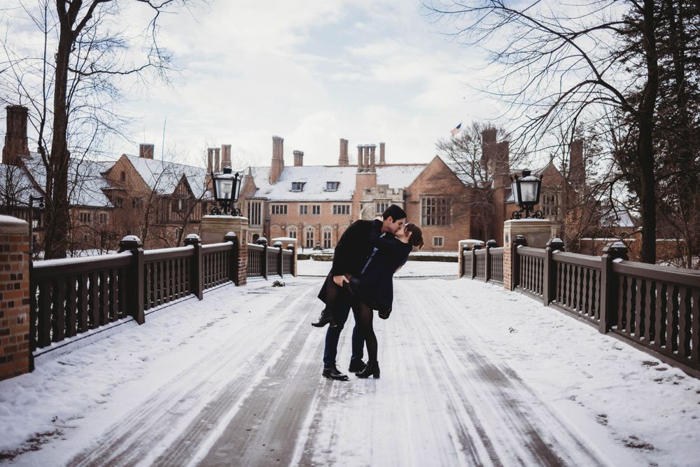 Snowy winter landscape with couple sharing intimate moment on campus walkway.