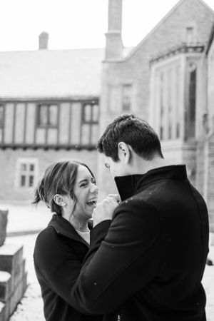 Black and white portrait of couple laughing together outdoors.