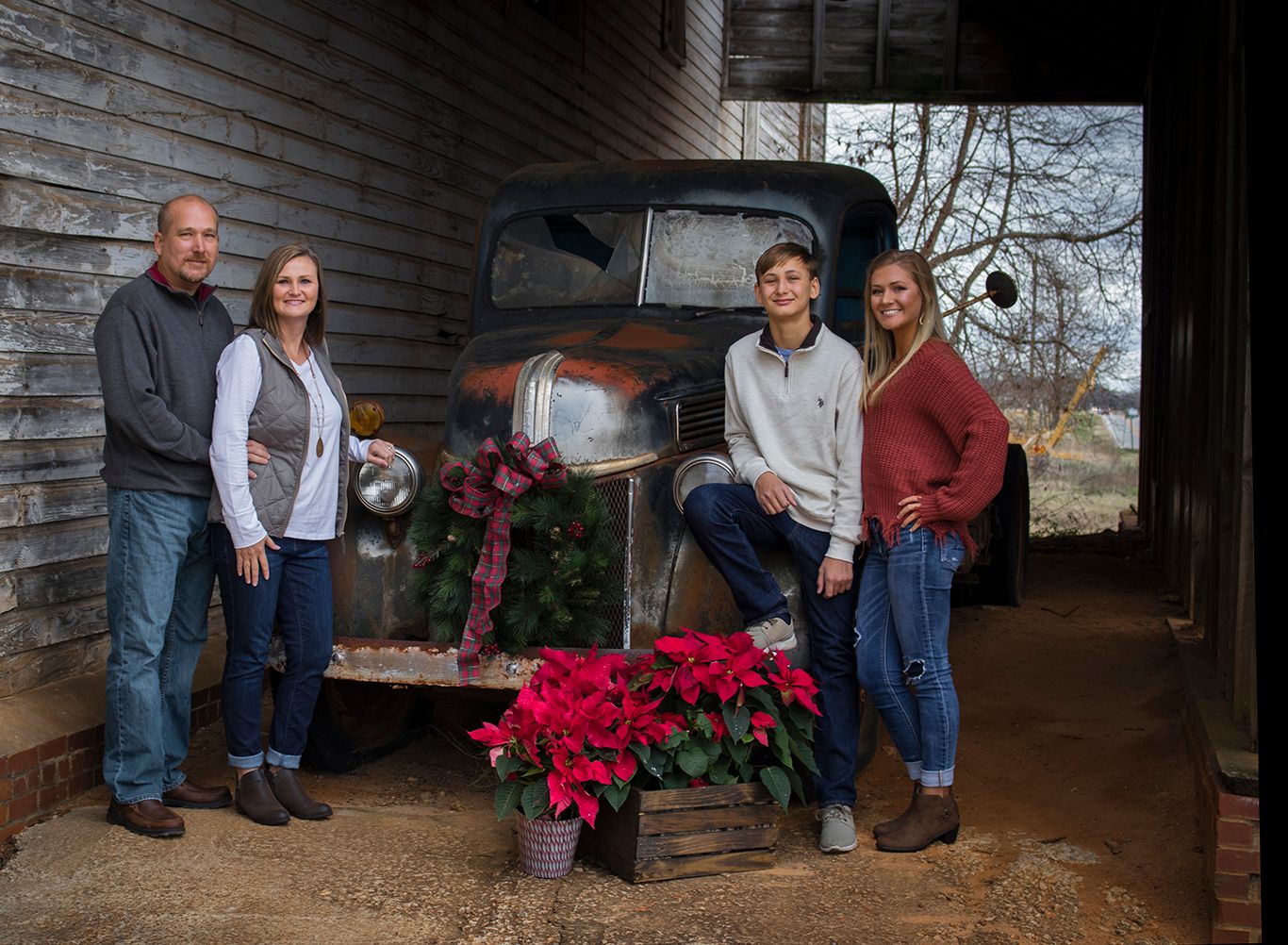 Family posing in front of an old truck for Christmas