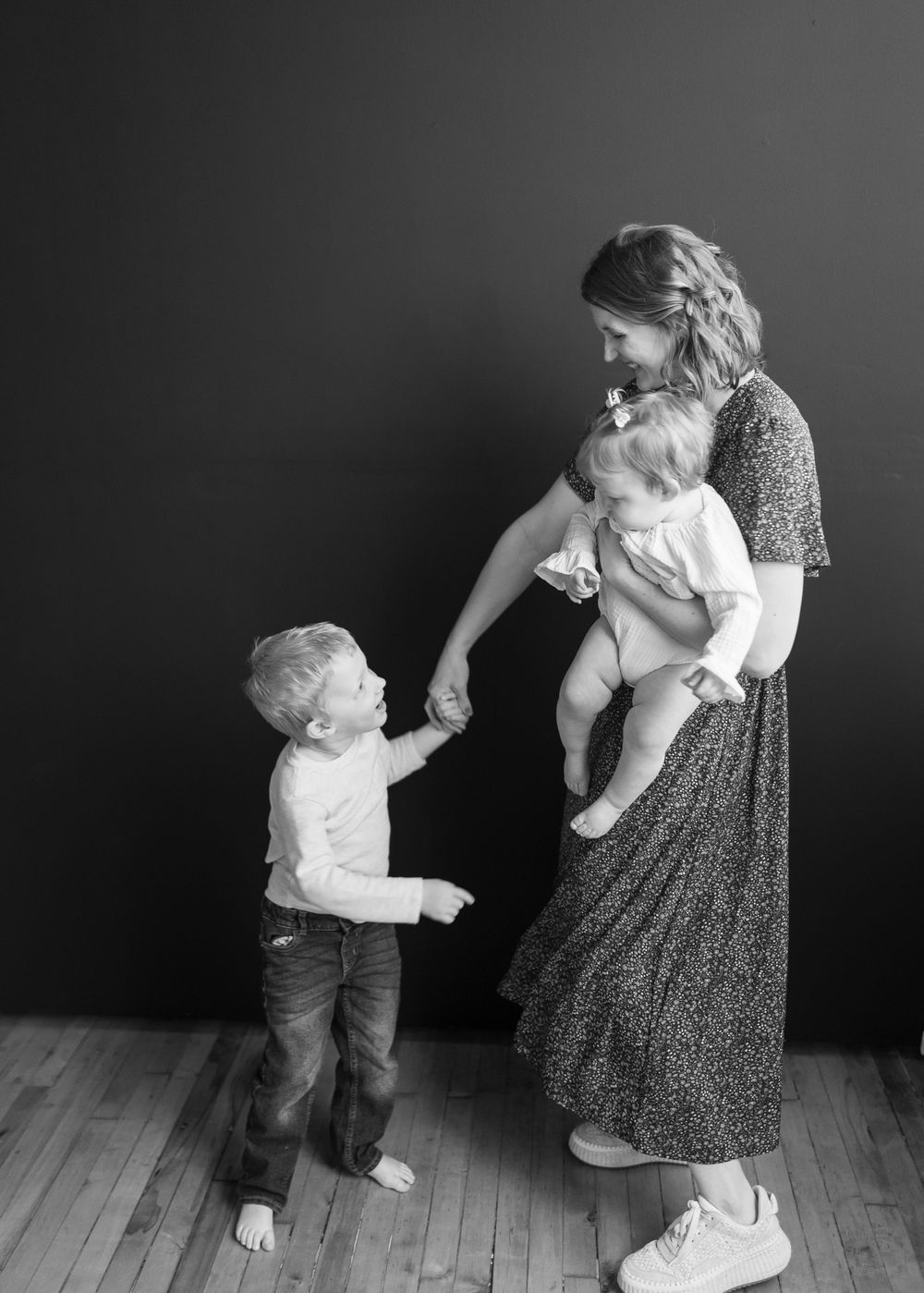 A black and white candid family moment showing connection between parent and children.