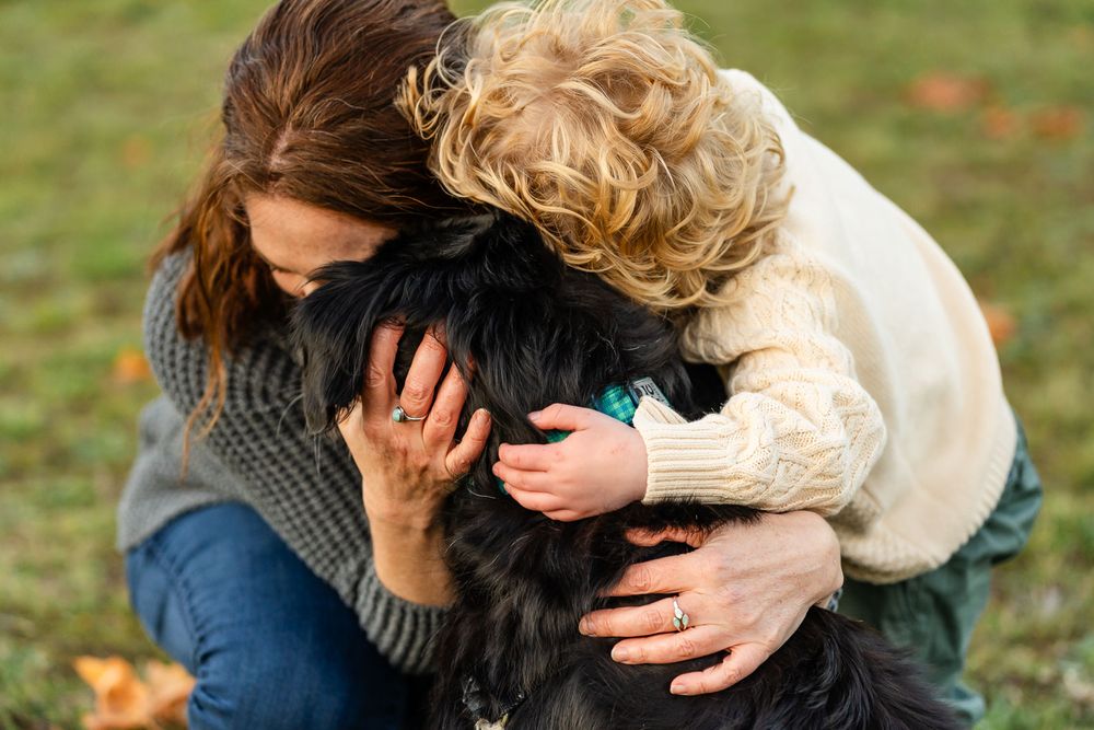 Mother and son embracing their black dog in North Bend.
