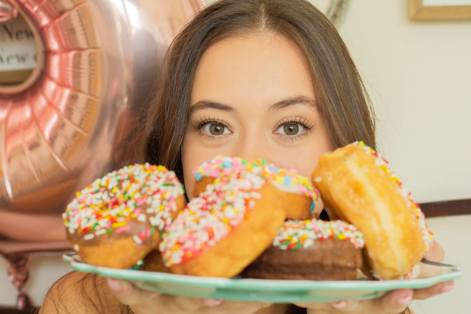 Close up shot of colorful frosted donuts on plate.