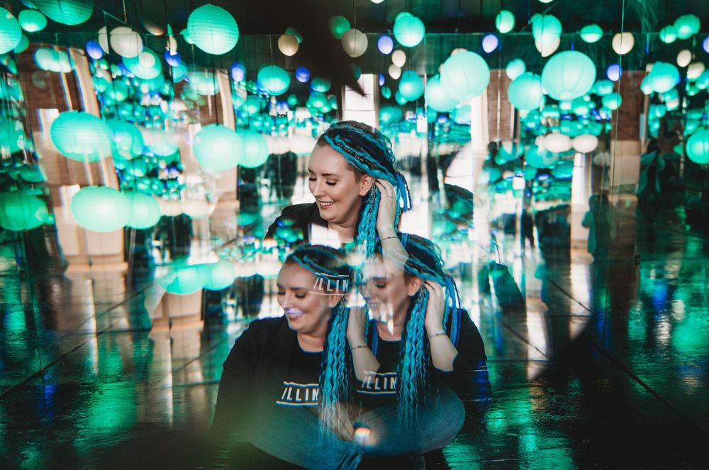 Artistic portrait with teal and turquoise lantern installation creating magical ambiance.