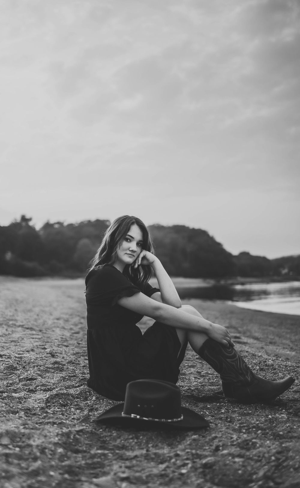 Black and white beach portrait showcases casual style with boots and dark clothing.
