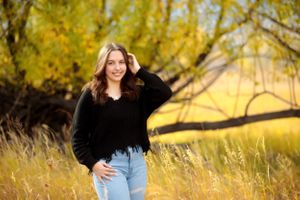 Fall portrait session featuring yellow trees and natural lighting in an outdoor setting.