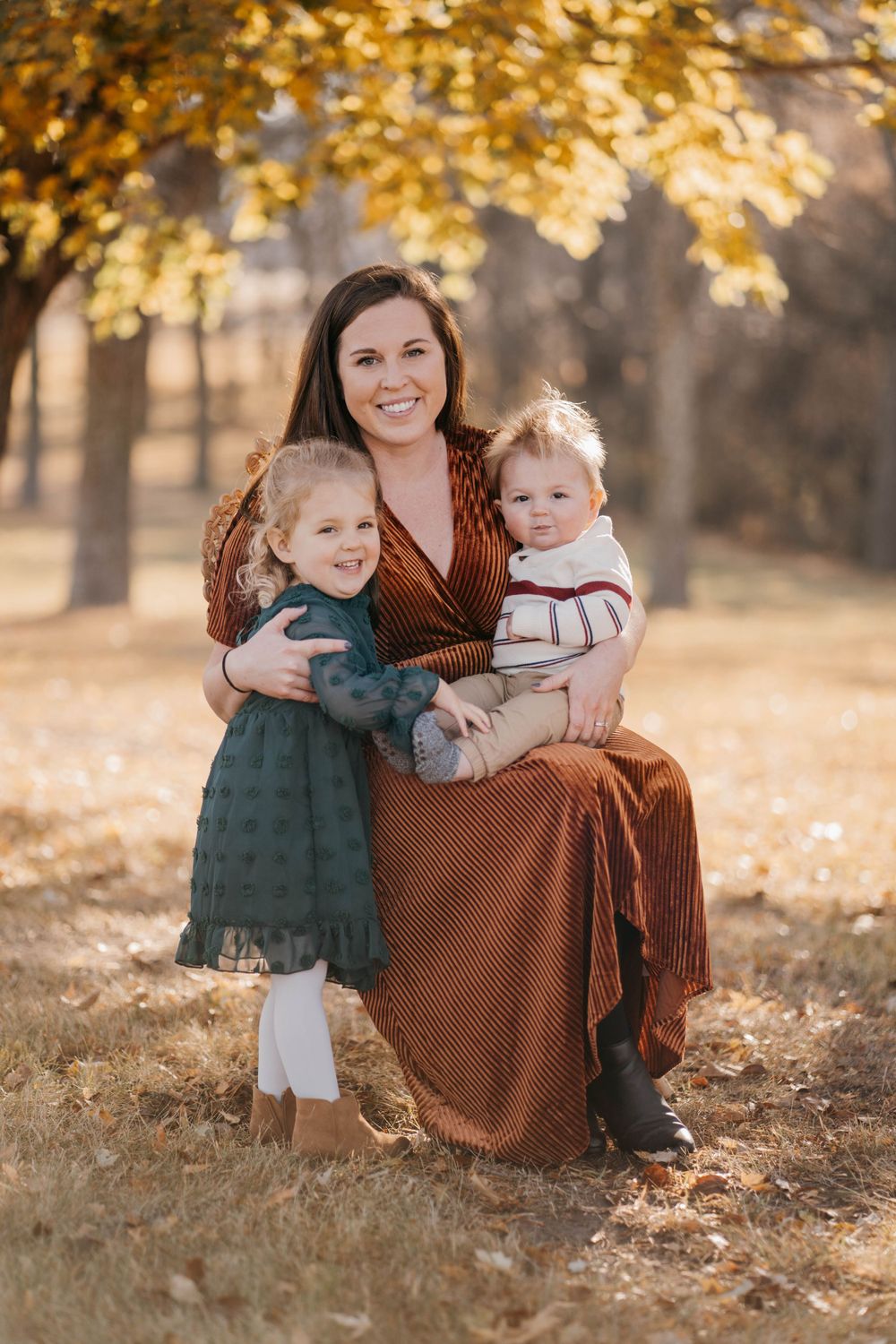 Autumn family photography session with fallen leaves and warm earth tones.