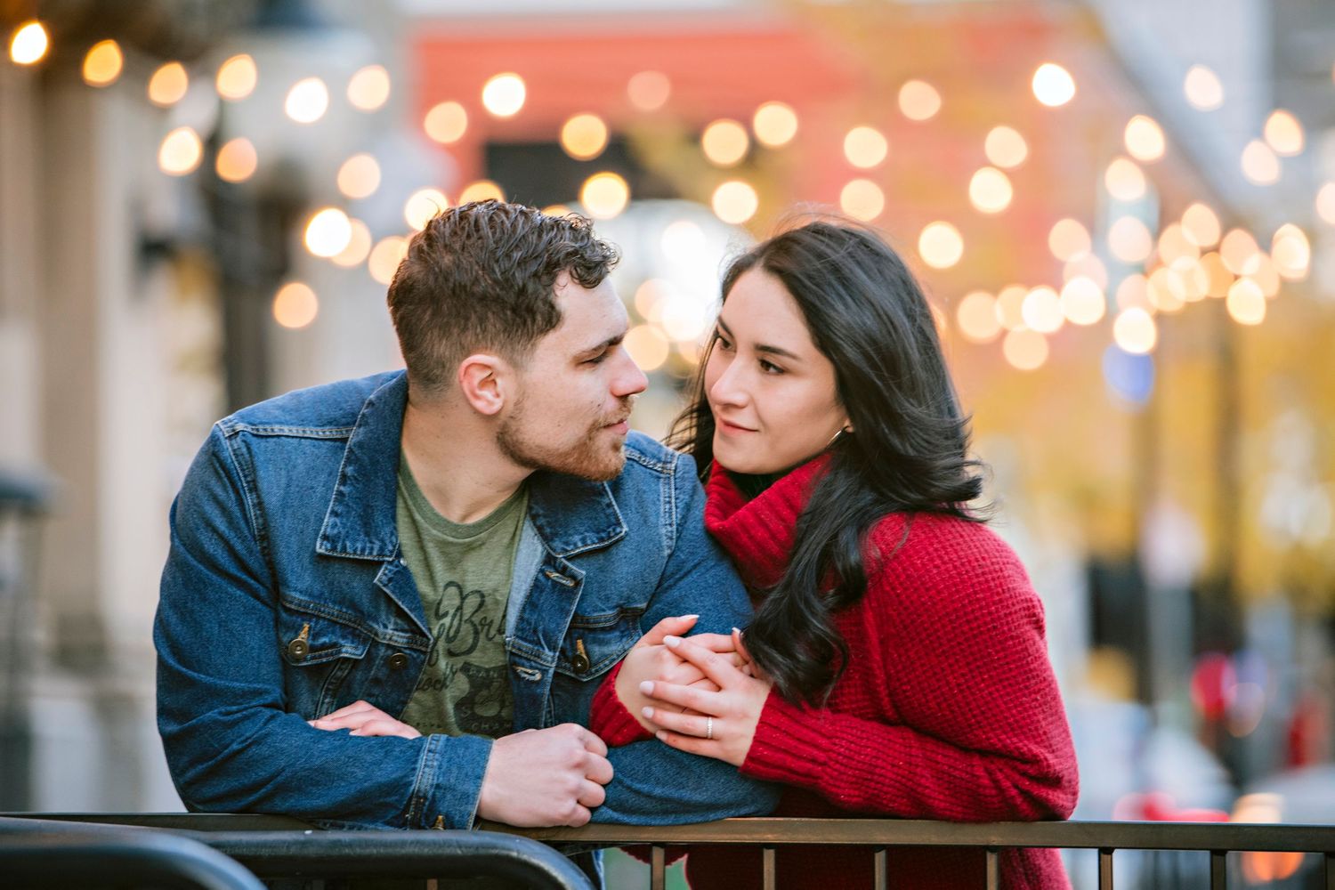 An engaged couple embraces under the lights in downtown Boise