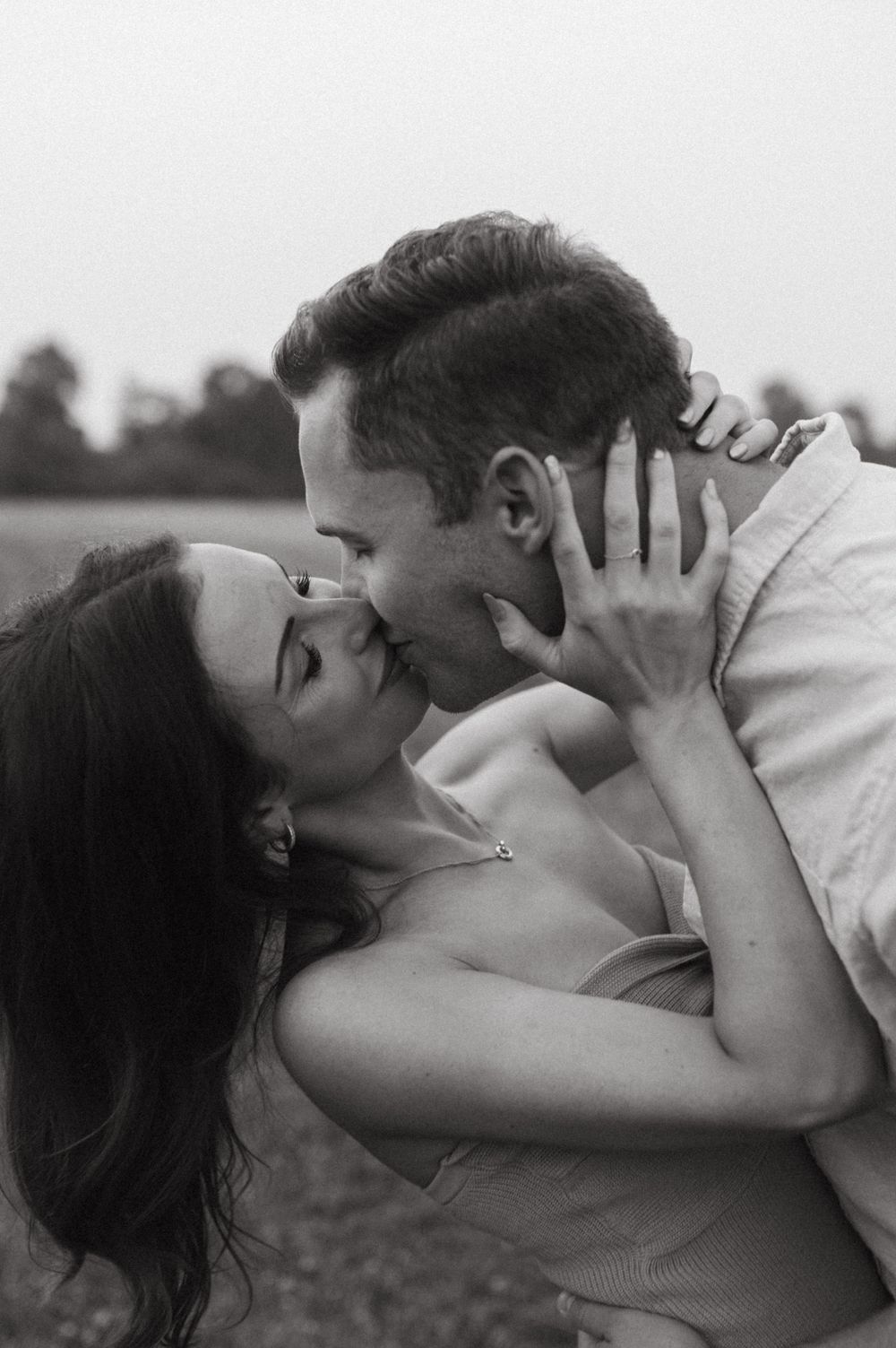 A black and white romantic photograph capturing an intimate moment between lovers.