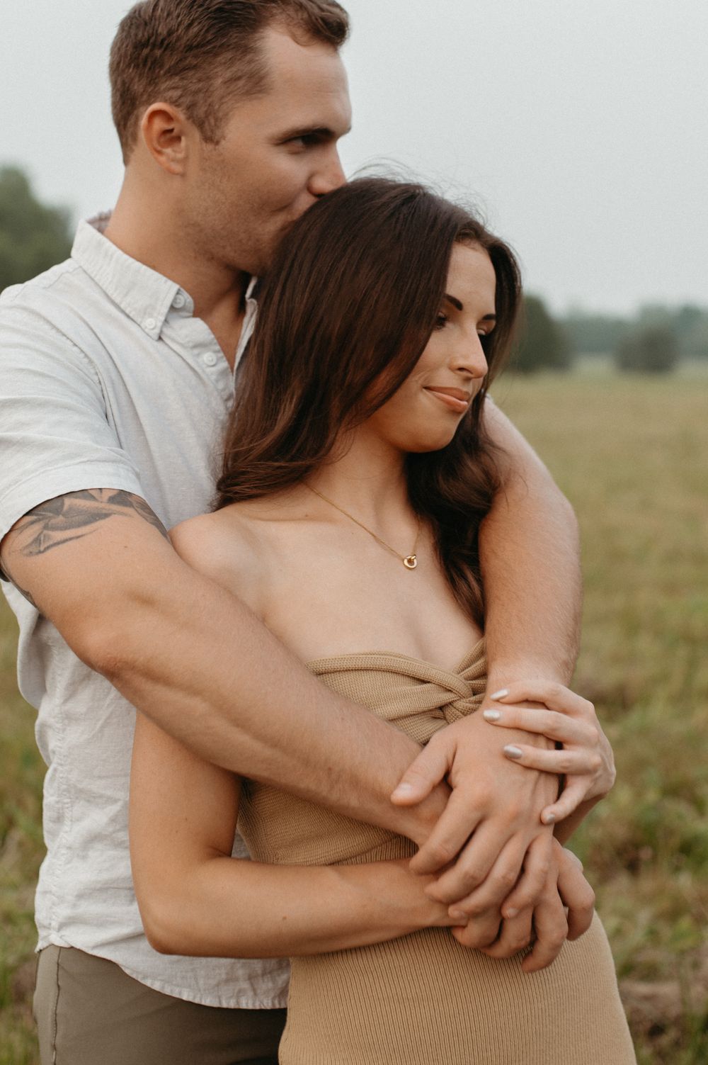 An intimate moment shared between a couple in a peaceful meadow setting.