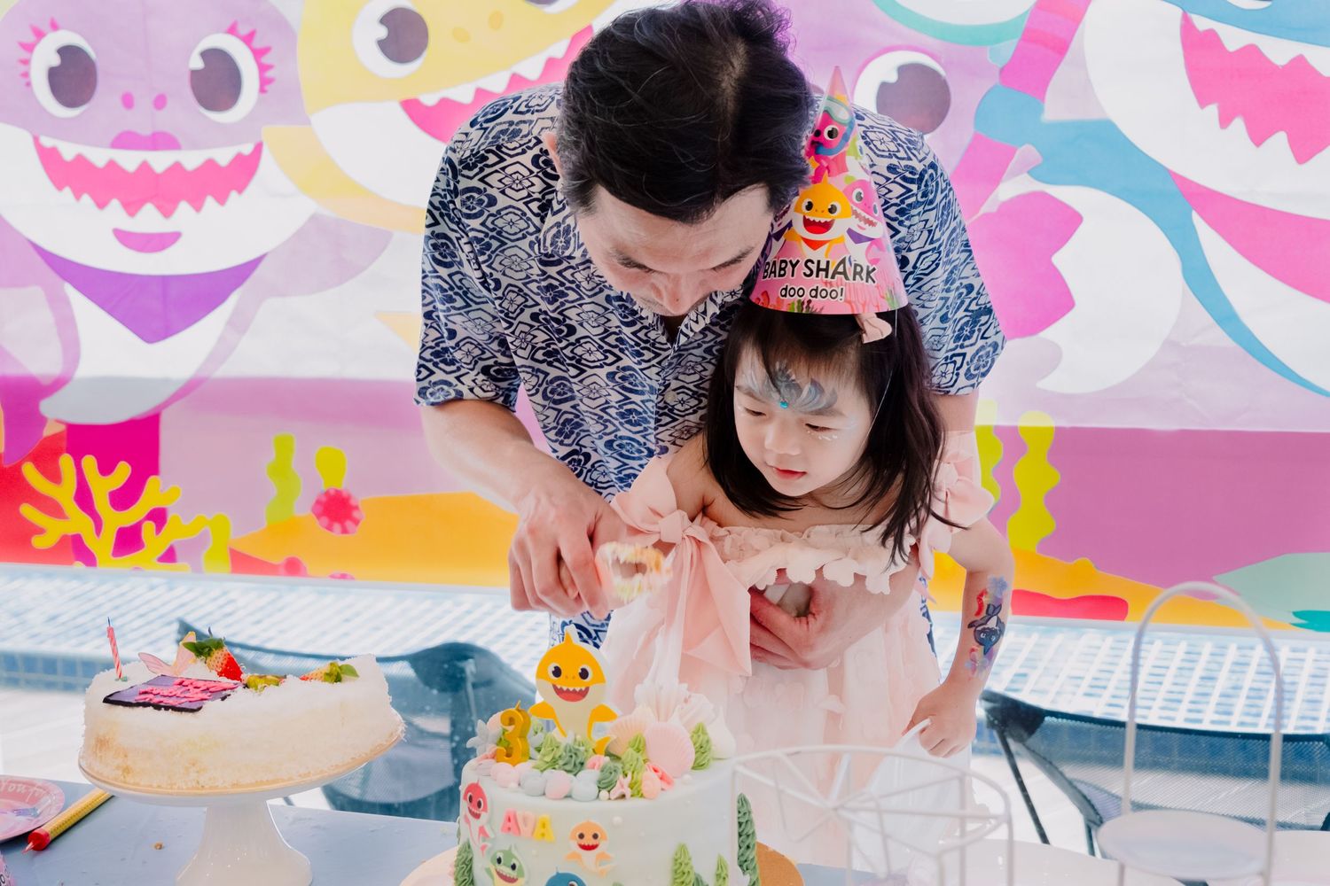 A birthday celebration with colorful shark-themed decorations and cake.