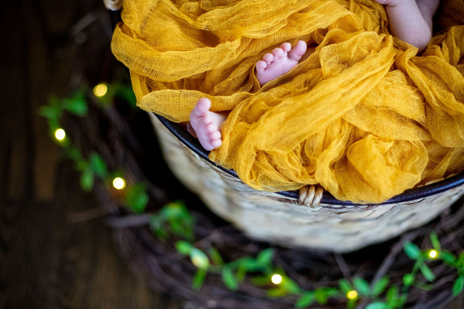 Yellow tulle fabric flowing over a basket with green bokeh lights in the background.