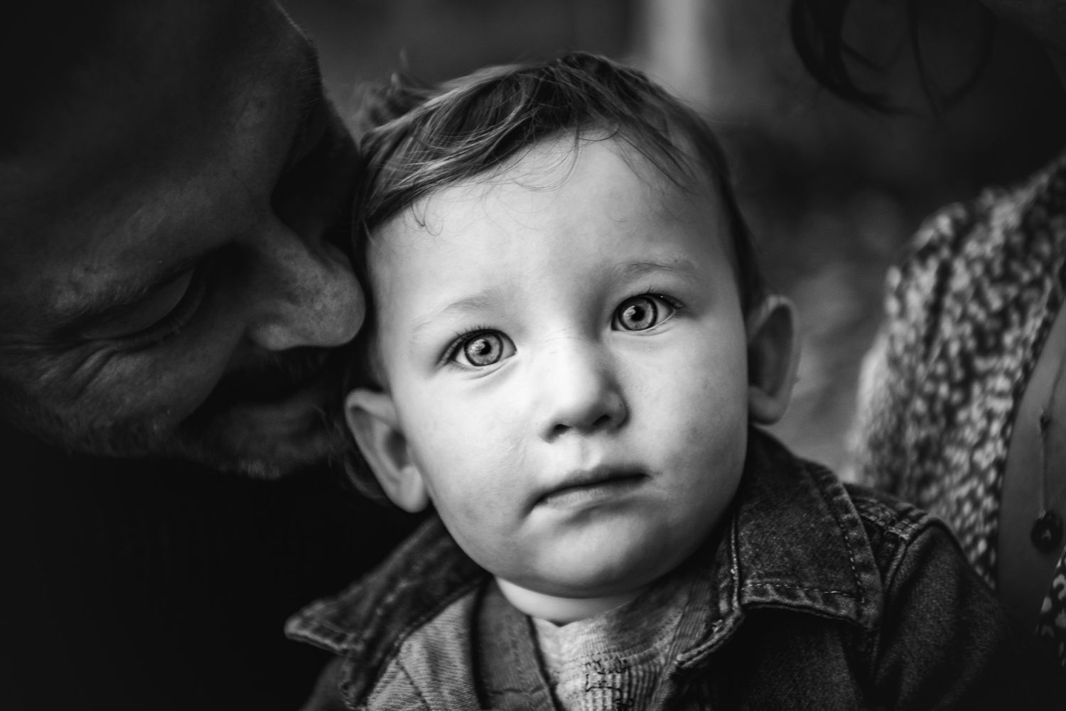 Black and white image of a 1 year old boy held by his father.