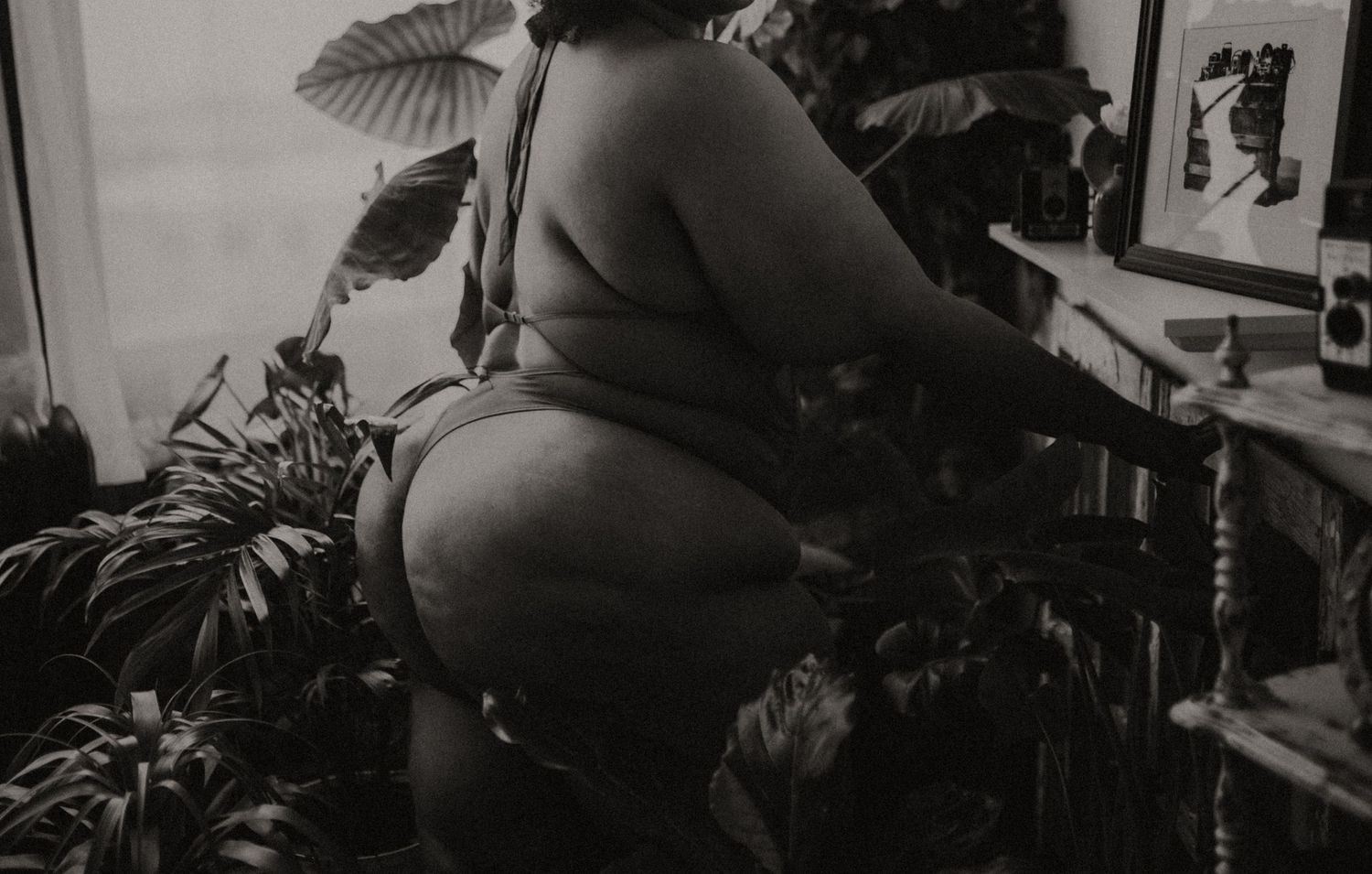 Plus size boudoir booty pose around plants