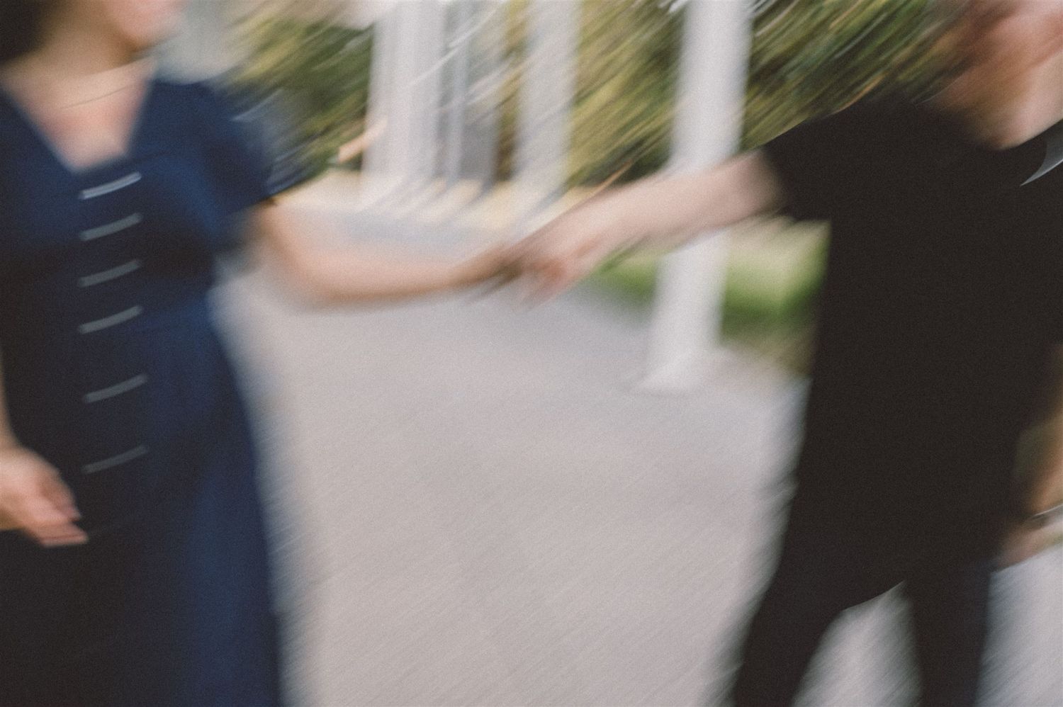 A blurred motion photograph of two people dancing together outdoors.