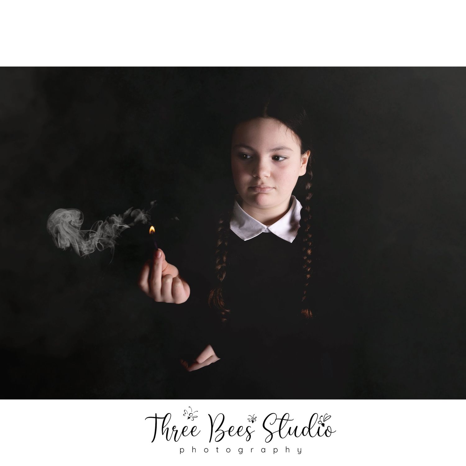 Dramatic portrait with braids and white collar featuring smoke effect against dark background.