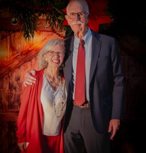 Holiday portraits of couples in formal attire against a red-lit rustic background.