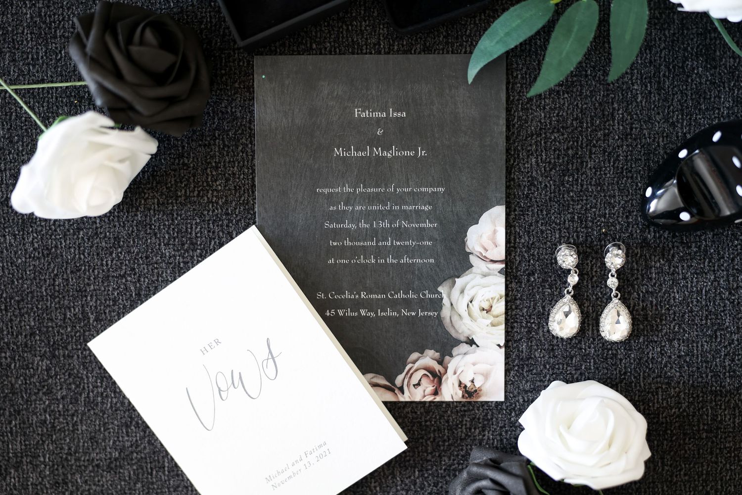 Wedding invitation suite styled in black with white roses and pearl earrings.