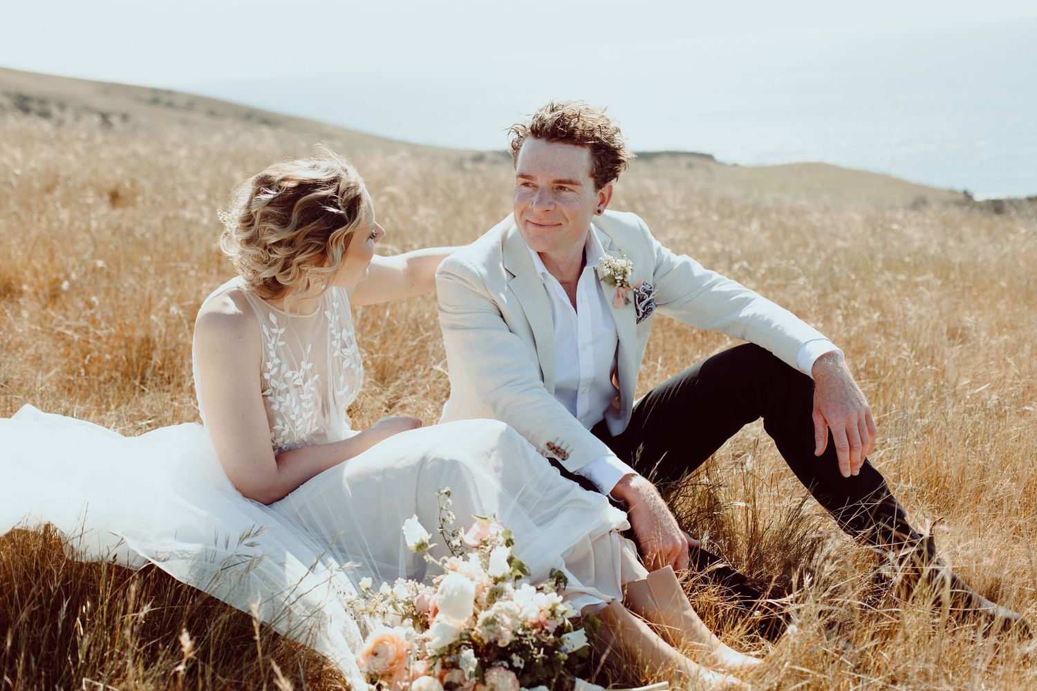 Two people relaxing together in a golden wheat field on a sunny afternoon.