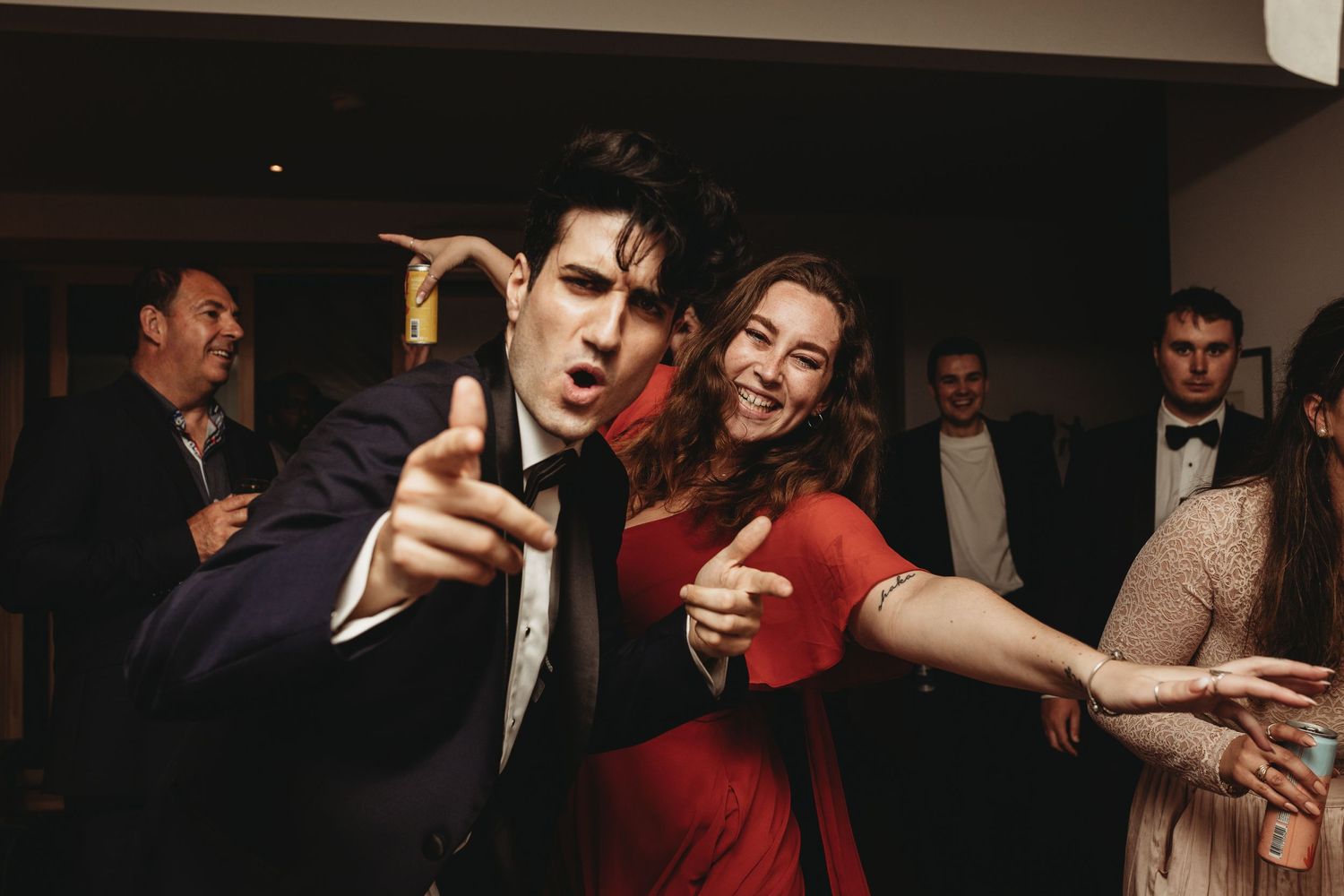 Lively wedding reception party scene with guests dancing in formal attire.