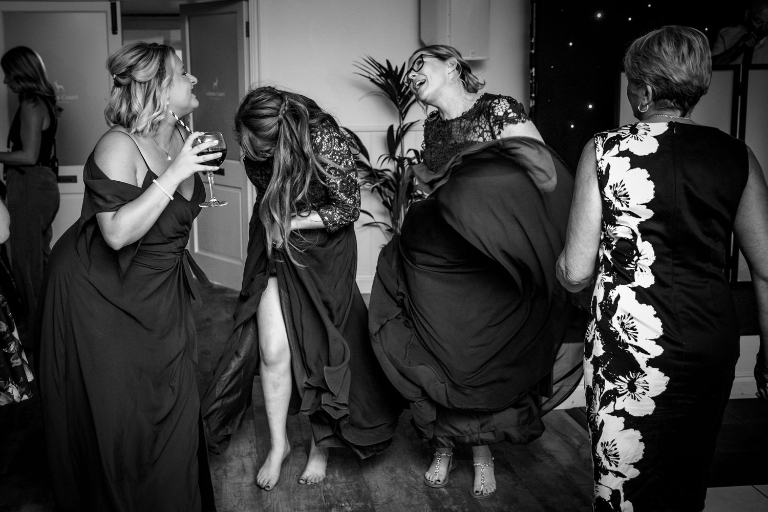 Black and white photos capturing energetic dancing at wedding reception.