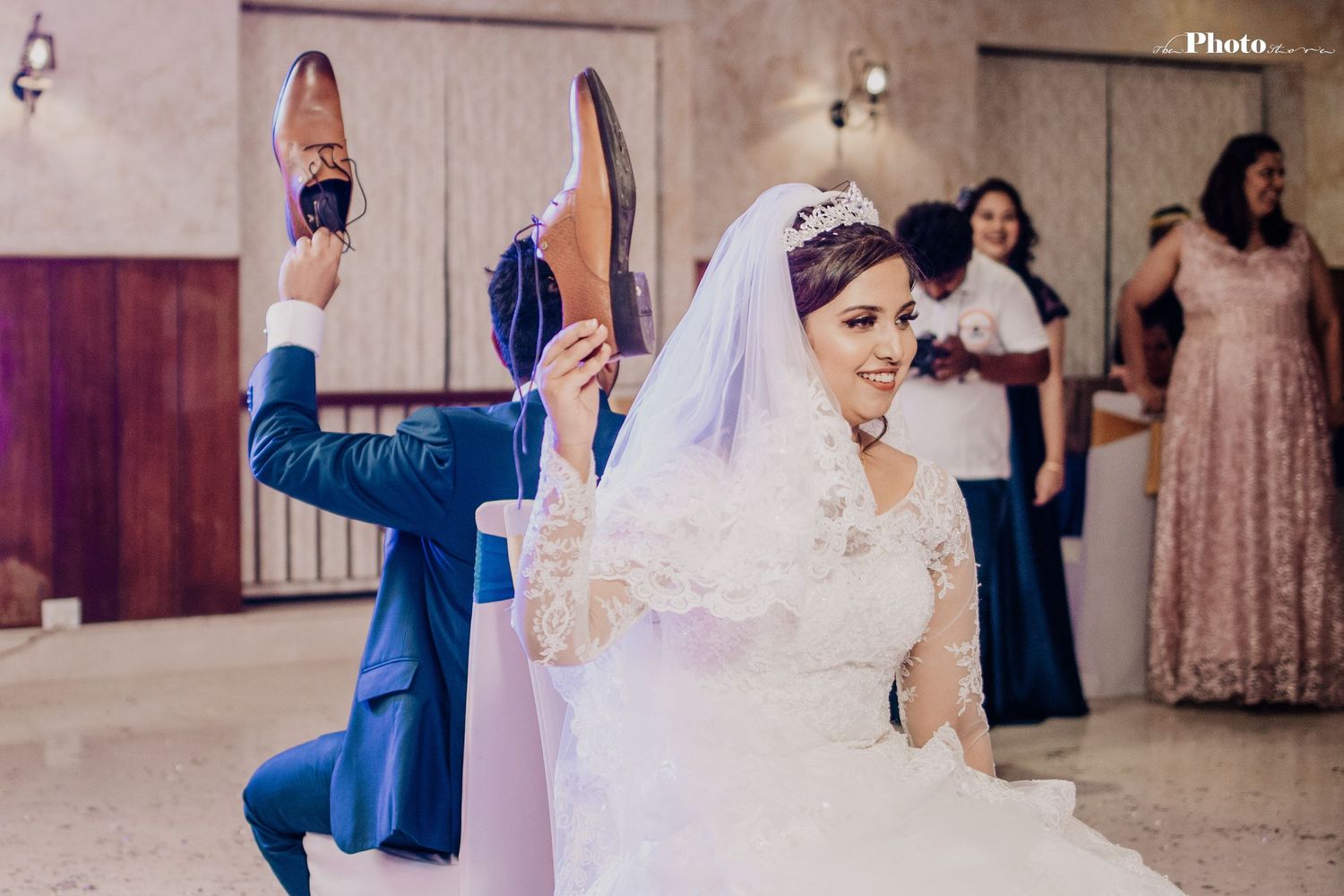 A wedding celebration scene with guests raising their arms in celebration on the dance floor.