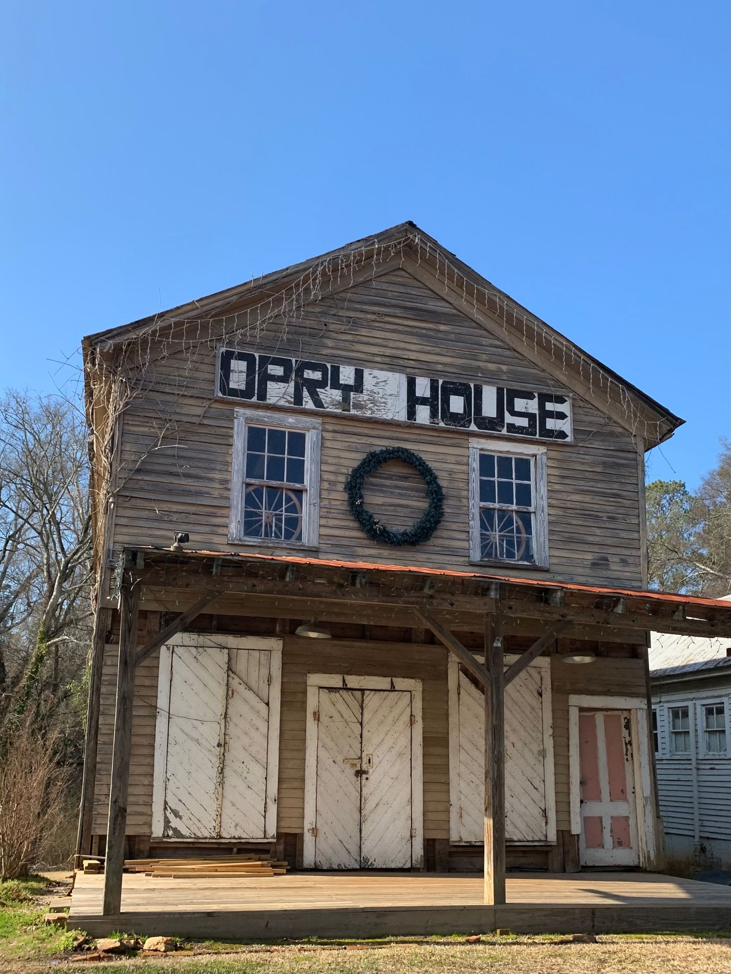 Rustic wooden Opry House building with weathered siding and wreath decoration.
