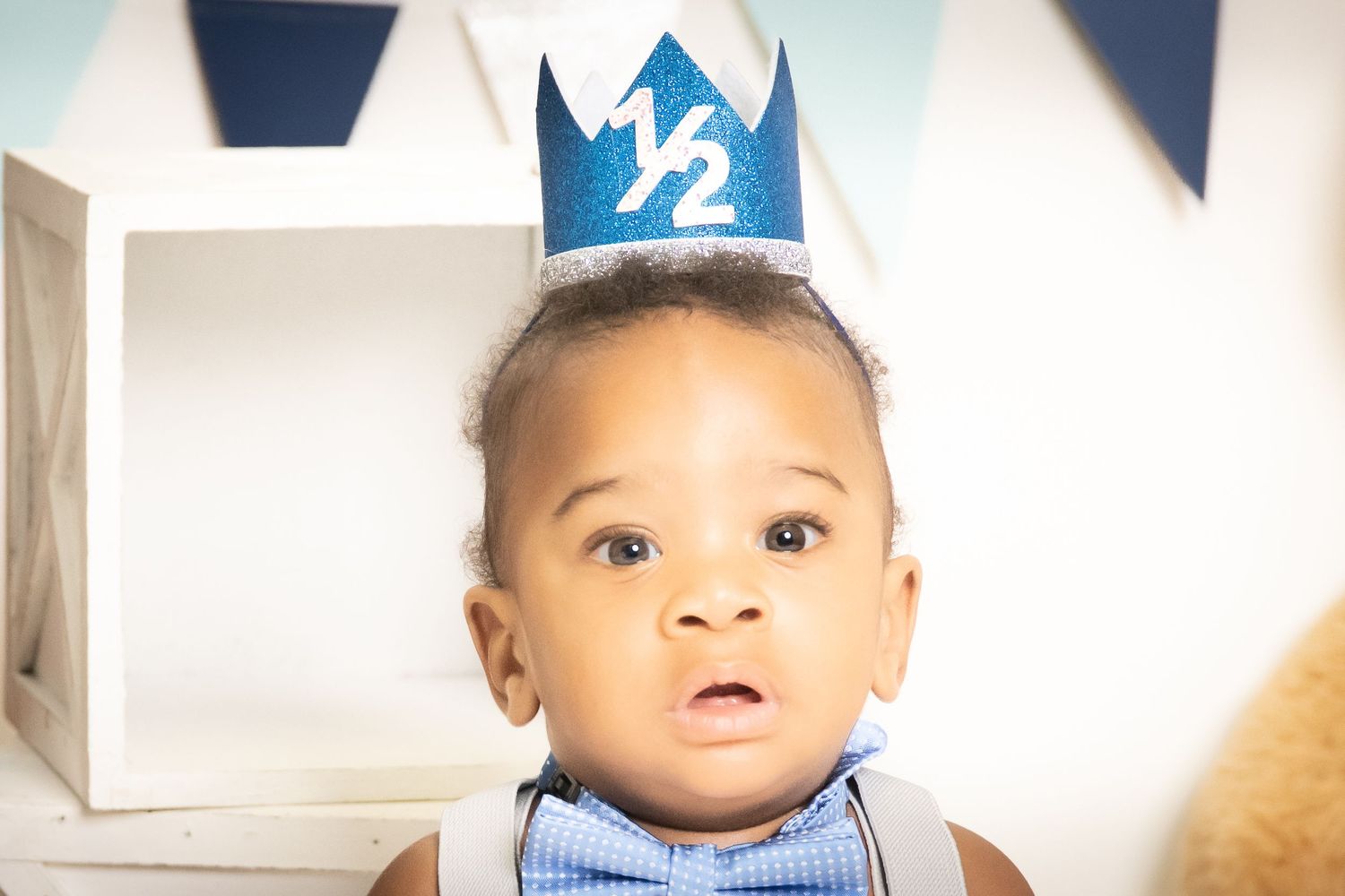 Baby milestone photography setup with blue party decorations.