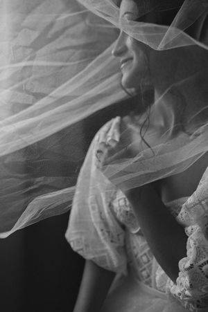 Black and white portrait of bride with flowing veil creating a dreamy ethereal effect.