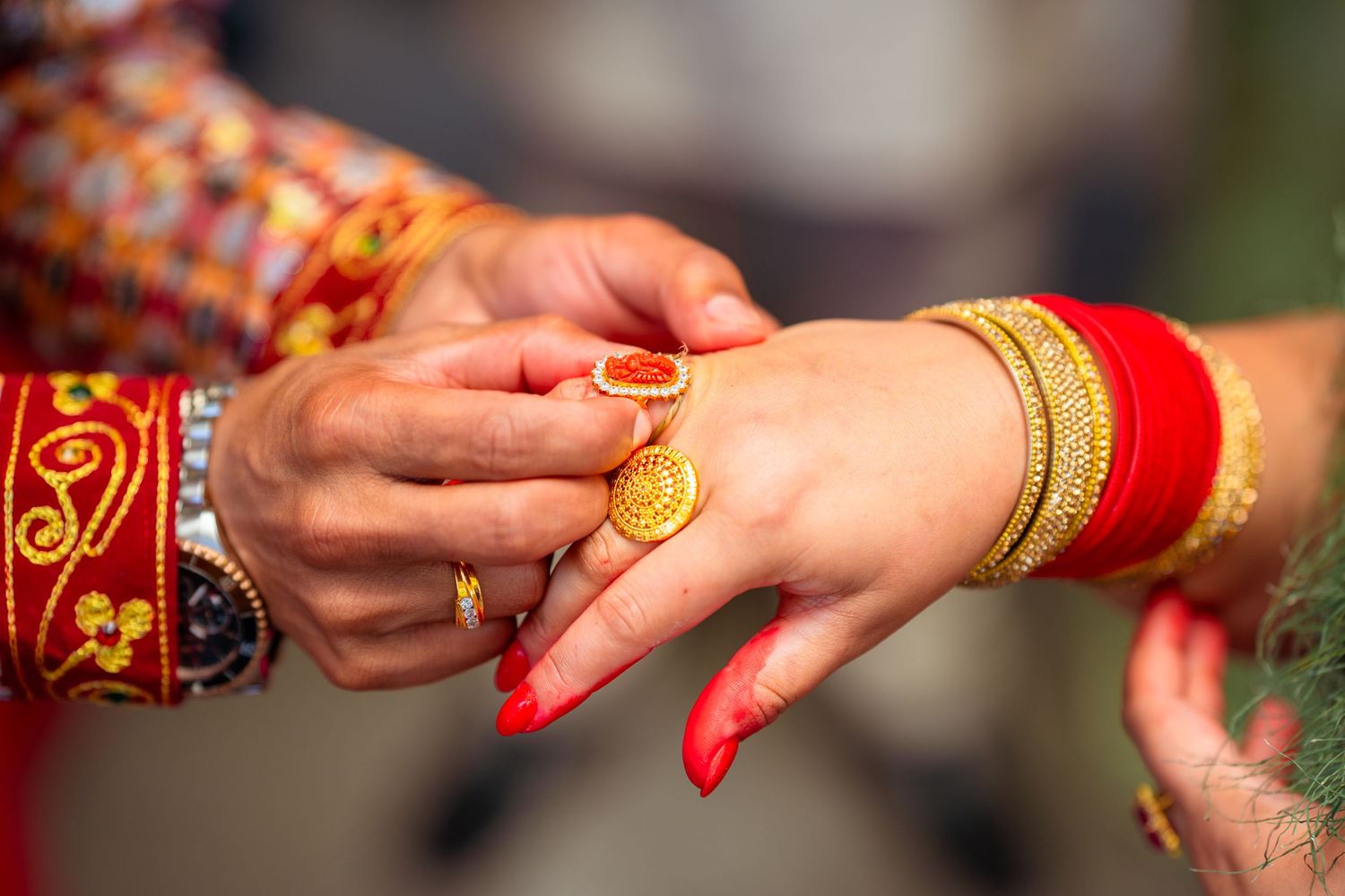 Close-up of traditional ring exchange during Hindu wedding ceremony.